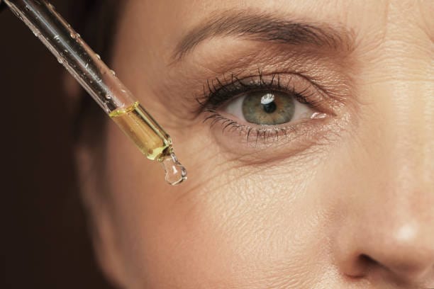 Closeup of female eye and dropper with rejuvenating serum, Closeup of female eye and dropper with rejuvenating serum