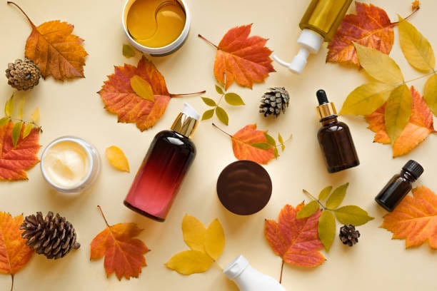 Autumn Skin Care products and autumn leaves on yellow background, flat lay, copy space. Seasonal beauty routine and organic cosmetic concept.