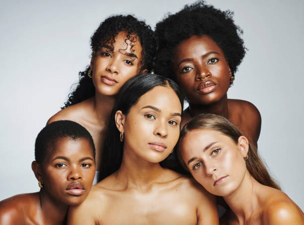 Skinimalism, Beauty portrait of a diverse group of beautiful women posing together against a grey studio background. Faces of female models with perfect, clear skin and complexion from a daily skincare routine